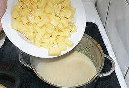 Suppe und Schlagsahne vermengen, aufkochen lassen und die Kartoffelstücke darin weich kochen.