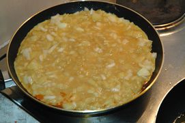 Die Ei-Kartoffel-Masse in eine beschichtete Pfanne geben und bei niedriger Hitze durchstocken lassen.