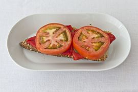 Mit Tomatenscheiben belegt