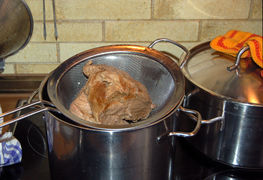 Das fertig gegarte Fleisch aus dem Topf nehmen und in Würfel schneiden.