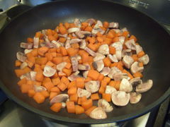 Wenn die Karotten angebraten sind, Champignons dazugeben und mit Rotwein ablöschen