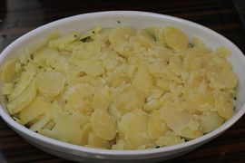Anschließend den Spinat und den Lachs mit den Kartoffelscheiben bedecken.